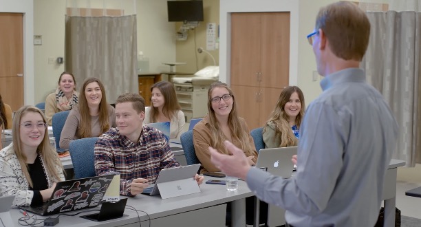 University students in a classroom with the founder