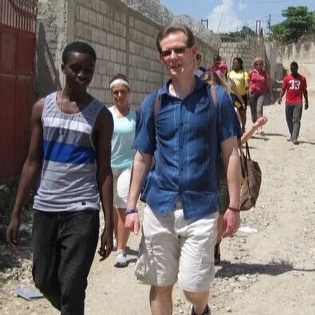 John walking through a community in Haiti