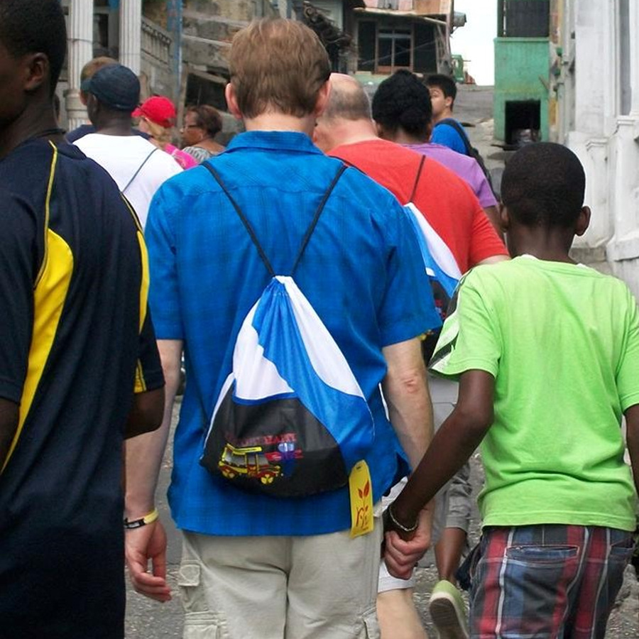 John in Liberia, wearing traditional dress, with a community member